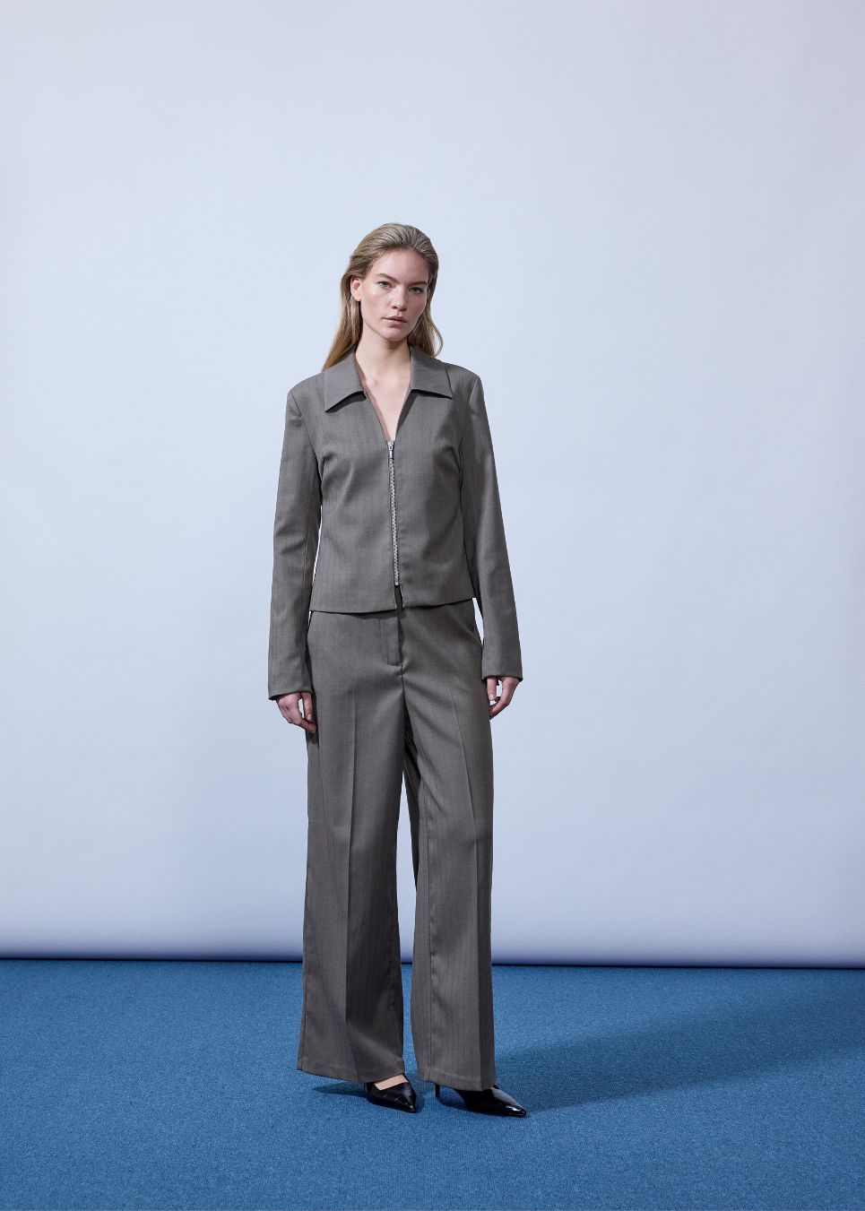 Figursyet blazer med lynlås lukning. Pedromd blazer har lange ærmer, V-udskæring og skjortekrave. Modellen er 175 cm og har en str. S/36 på.