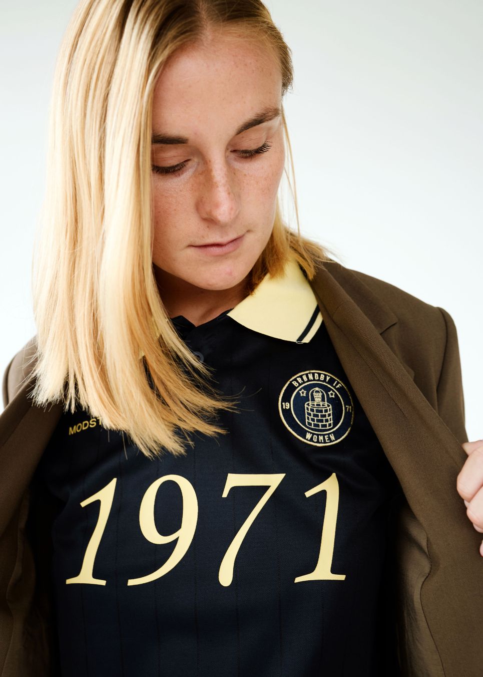 Fodbold jersey i mørkeblå med gule detaljer lavet i samarbejde med Brøndbys kvindehold. 1971 Polo har en løs pasform med stolpelukning og krave, samt lange ærmer med ribkant. Desuden har poloen Brøndby Womens og Modström logo på brystet.
