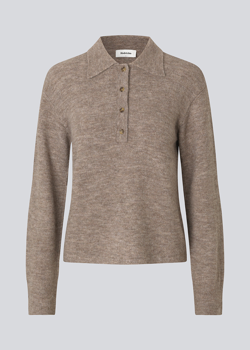 Strikket polo i brun med lange brede ærmer. Treemd polo har en stolpelukning og 4 knapper. 