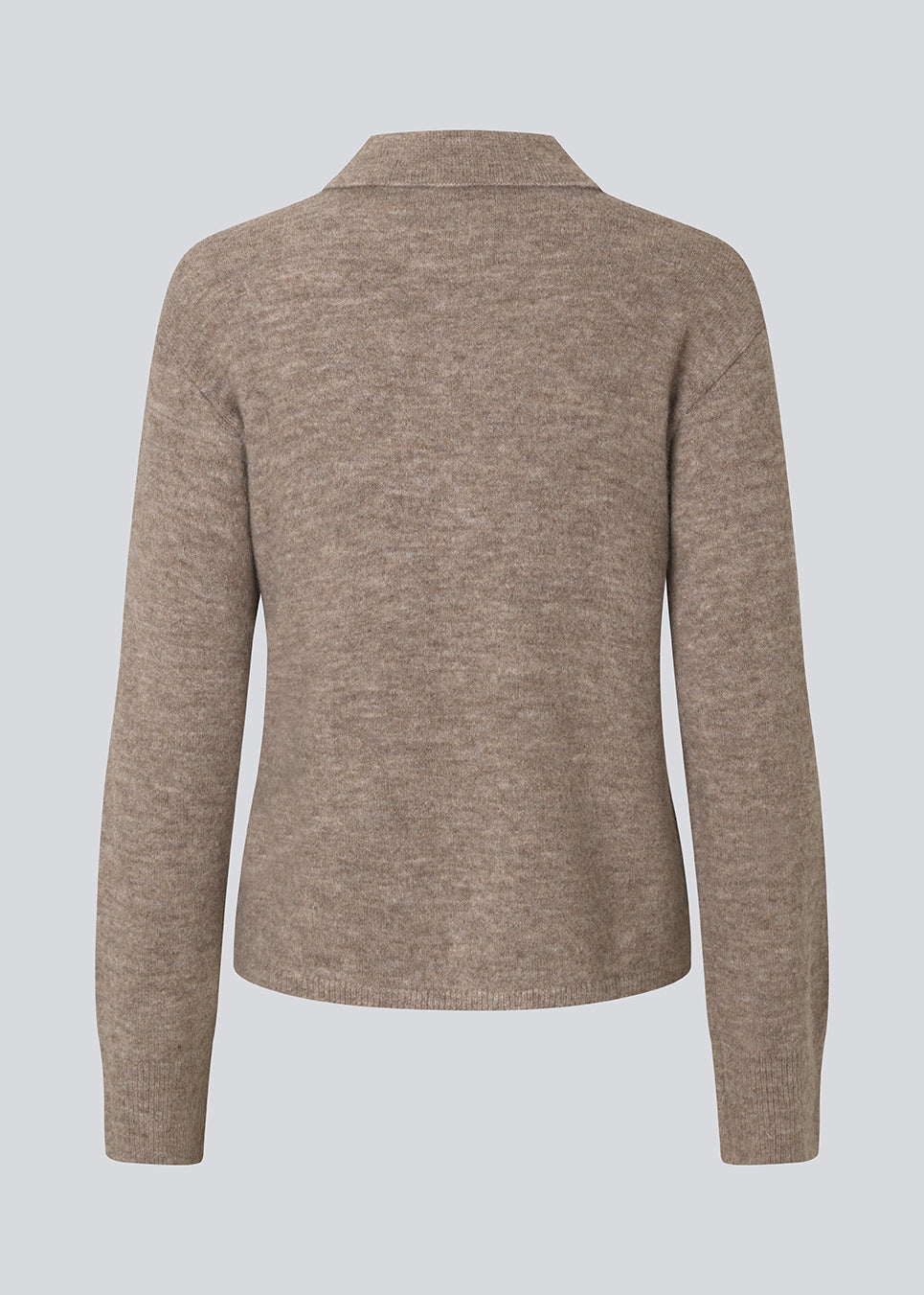 Strikket polo i brun med lange brede ærmer. Treemd polo har en stolpelukning og 4 knapper. 