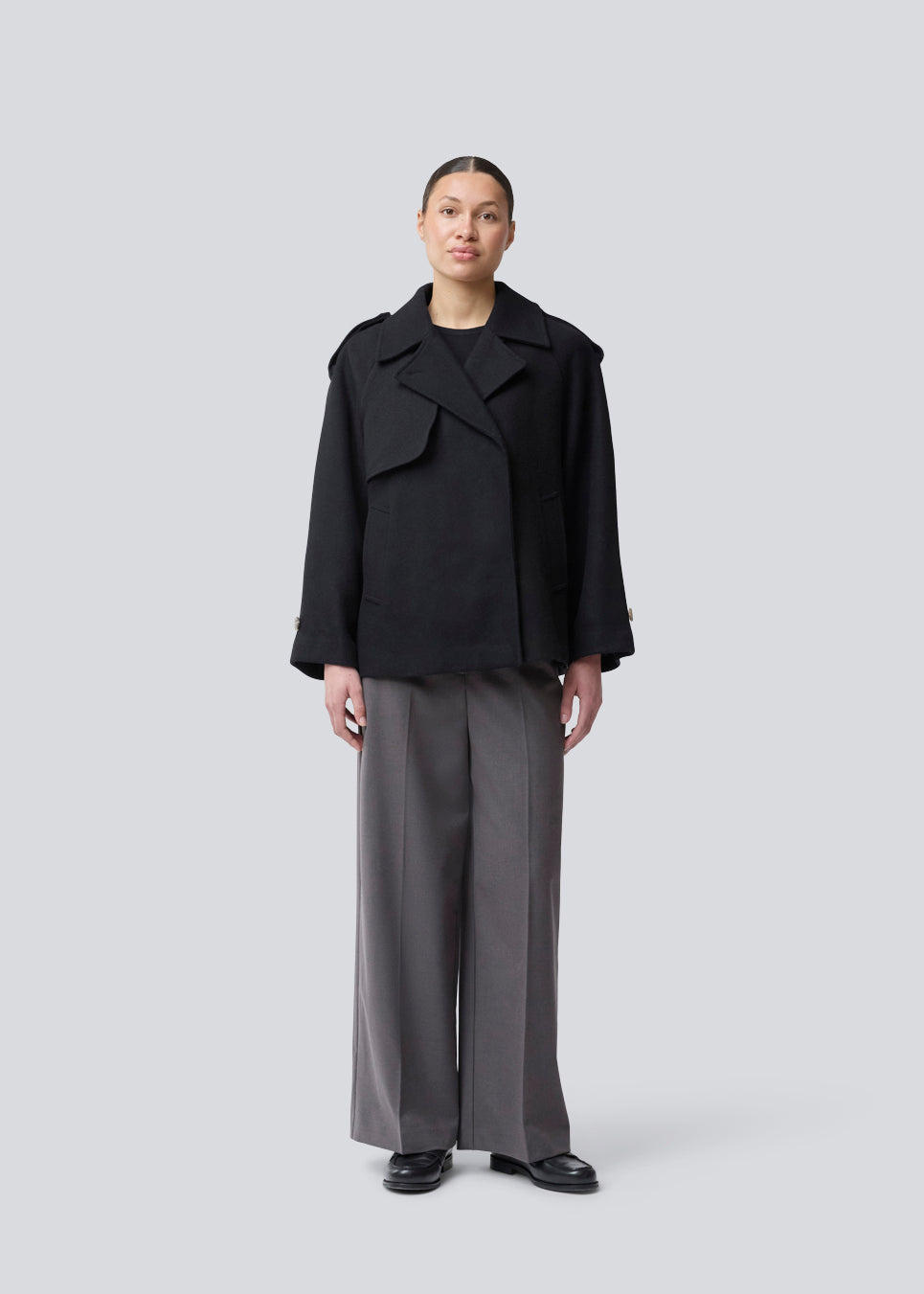 Cropped dobbeltradet uldfrakke med skjulte knapper. EsmundMD jacket har klassiske frakkedetaljer med raglanærmer og bredt bærestykke på ryggen. Med foer. Modellen er 175 cm og har en størrelse S/36 på.