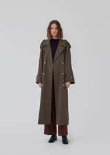 Oversized dobbeltradet trench coat i mørkebrun med bindebånd i taljen. EvieMD jacket har lav skuldersøm og lange, brede ærmer. Med foer. 