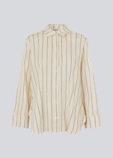 Hvid stribet skjorte i hørblanding med krave, knapper foran og bærestykke bagpå. FiaMD shirt har en løs pasform med lange brede ærmer. Modellen er 175 cm og har en størrelse S/36 på.