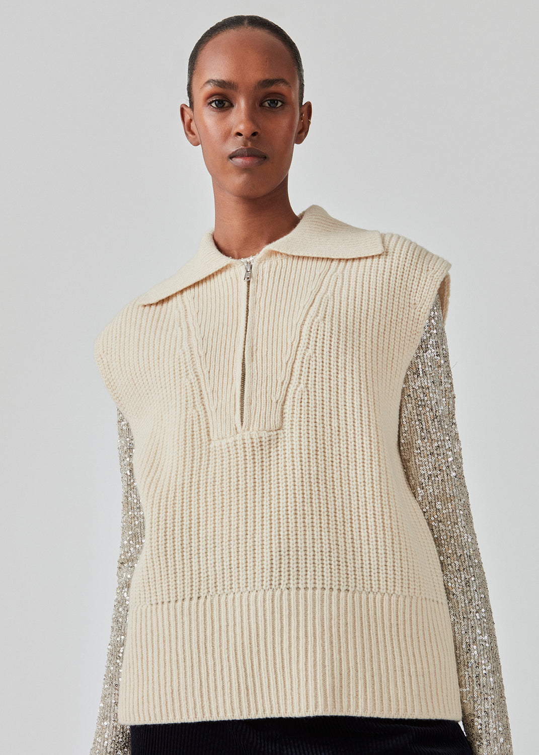 Ærmeløs strikvest i tyk uldkvalitet med rummelig pasform. FultonMD vest har halv lynlås og bred krave. Modellen er 175 cm og har en størrelse S/36 på.