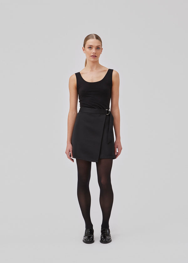 Wrap nederdel i mini længde. GavinMD skirt er fremstillet i en tung satin med slå om-effekt foran, som lukkes med bredt bælte og D-ring. Modellen er 175 cm og har en størrelse S/36 på.