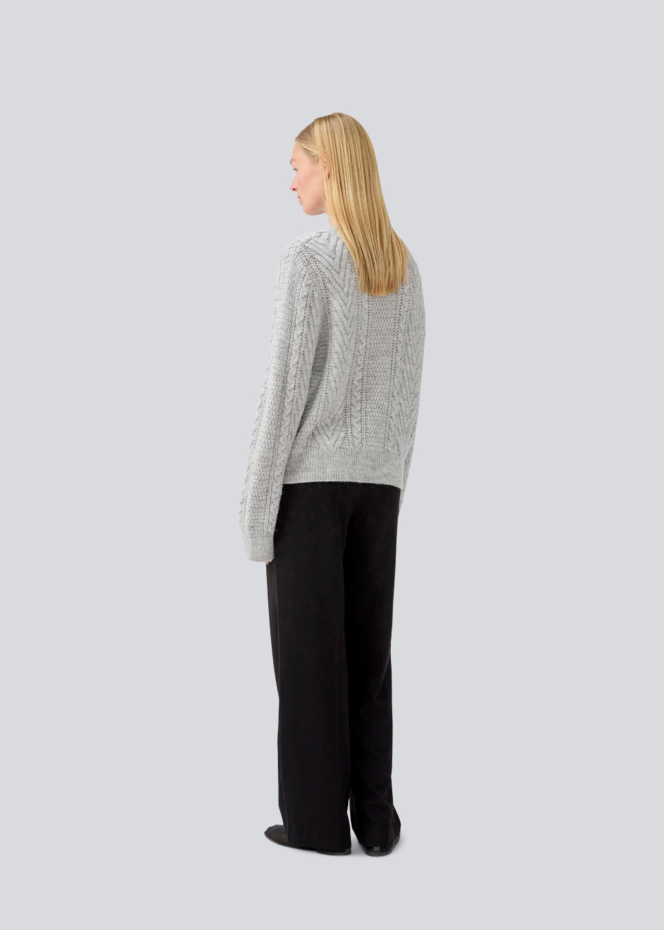 Kabelstrikket grå trøje i kvalitet med uld. GrannonMD o-neck har en afslappet pasform med lange ærmer og rund hals, med ribkant ved hals, ærmer og forneden. Modellen er 175 cm og har en størrelse S/36 på.