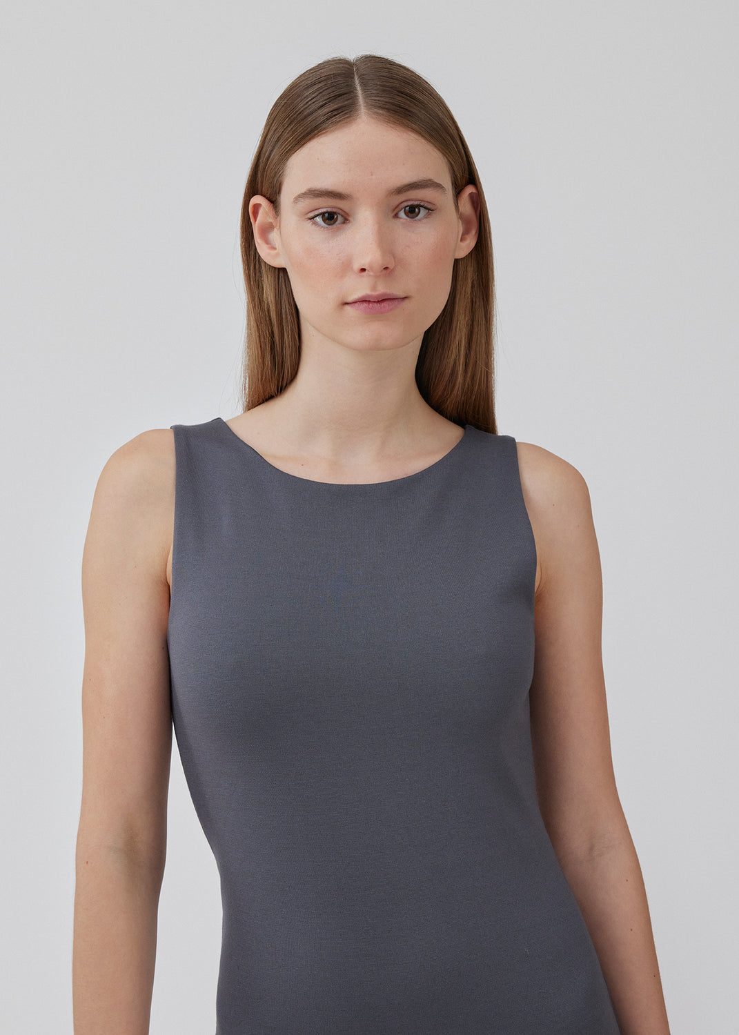 Tætsiddende kjole i grå med høj bådudskæring. HakanMD dress er ærmeløs og har en længde, der går til knæene. Modellen er 175 cm og har en størrelse S/36 på.<br>