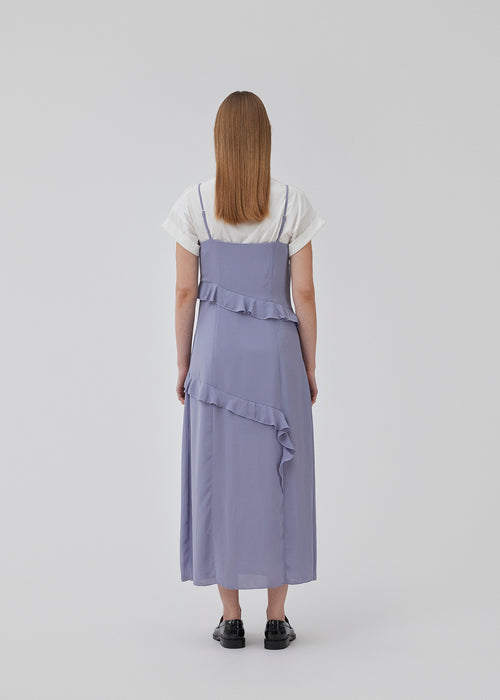 Midi kjole i genanvendt kvalitet med asymmetrisk flæsedetalje og slids i den ene side. HalimaMD dress har v-hals med smalle justerbare skulderstropper. Modellen er 175 cm og har en størrelse S/36 på.