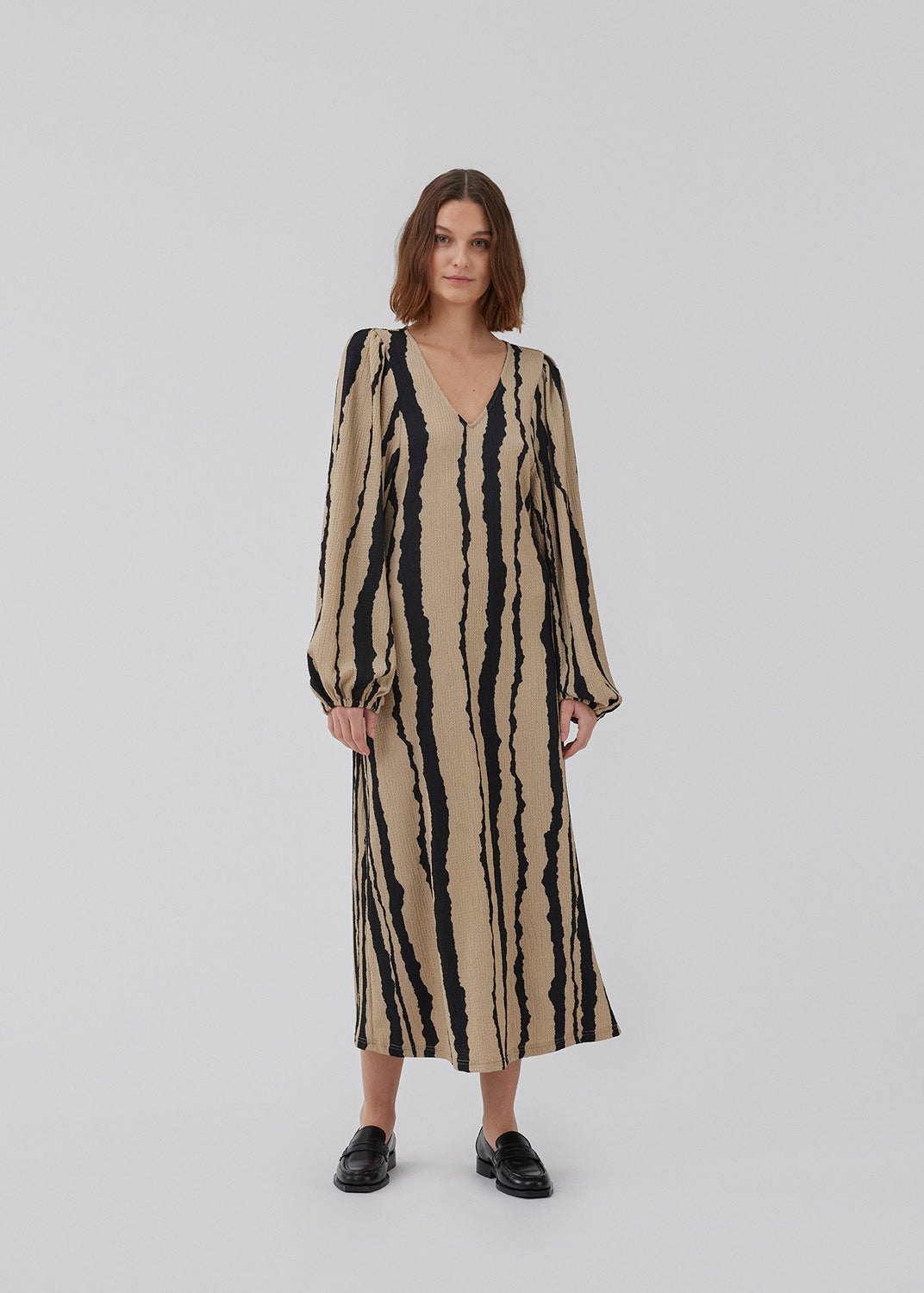 Printet midi kjole med v-udskæring i halsen og lange ballonærmer med elastik. HarlandMD print dress har en løs pasform. Modellen er 175 cm og har en størrelse S/36 på.