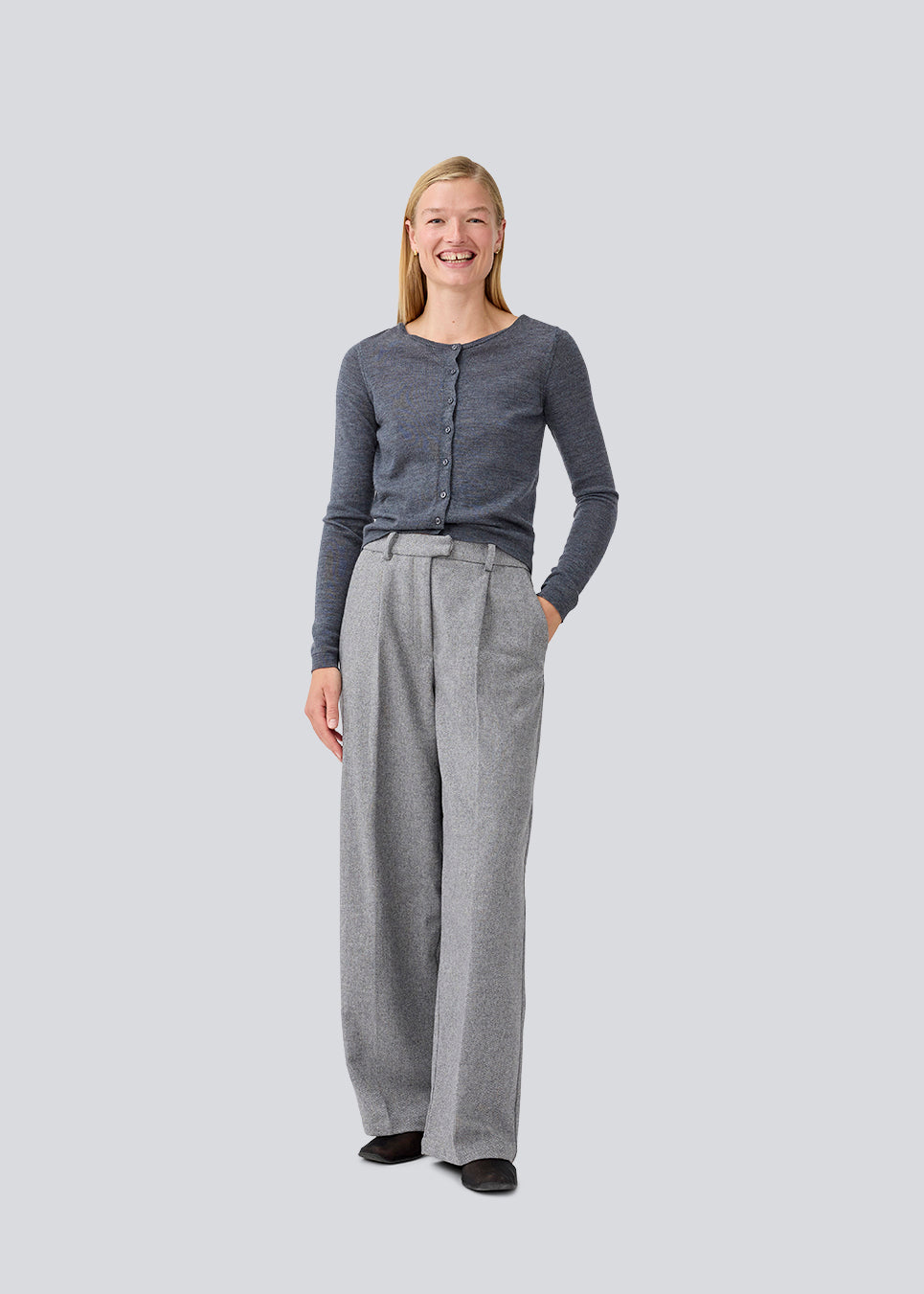 Tætsiddende mørkegrå cardigan i blød strik. HirokiMD short cardigan har en rund hals og knappelukning fortil. Modellen er 177 cm og har en størrelse S/36 på.