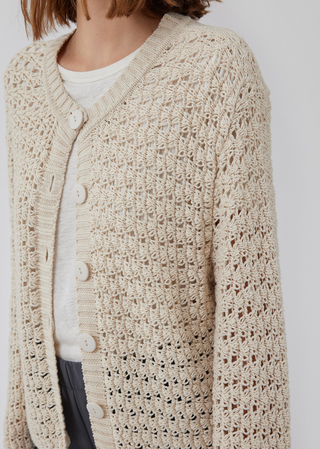 Cardigan i hæklet look af økologisk bomuld. HobbsMD solid cardigan har et afslappet udtryk med rund hals med knaplukning fortil samt lange ærmer. Modellen er 175 cm og har en størrelse S/36 på.