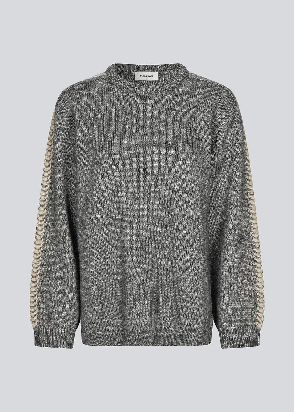 Blød mørkegrå strik med beige detalje på ærmet. LineMD o-neck har en rund hals og en løs pasform, samt slidser i siderne. Modellen er 177 cm og har en størrelse S/36 på.