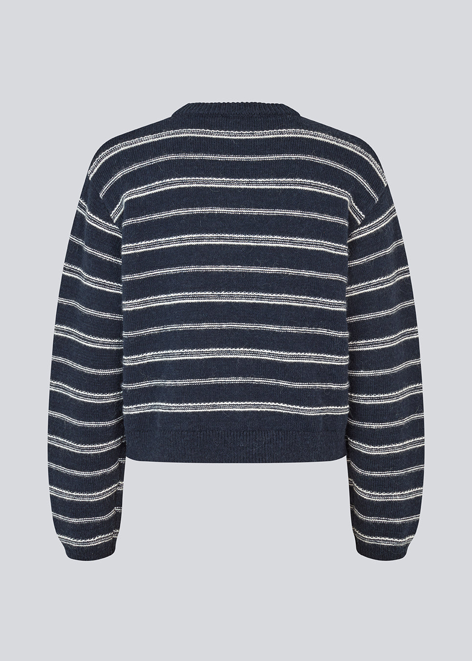 Oversize stribet strik med med rund hals. LineusMD stripe o-neck har lange ærmer med vide og en lav skuldersøm. Modellen er 177 cm og har en størrelse S/36 på.