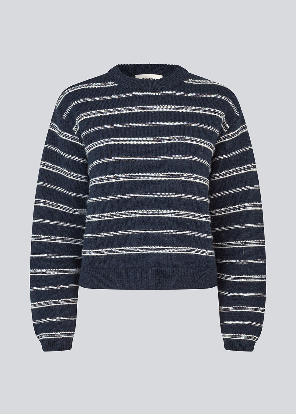 Oversize stribet strik med med rund hals. LineusMD stripe o-neck har lange ærmer med vide og en lav skuldersøm. Modellen er 177 cm og har en størrelse S/36 på.