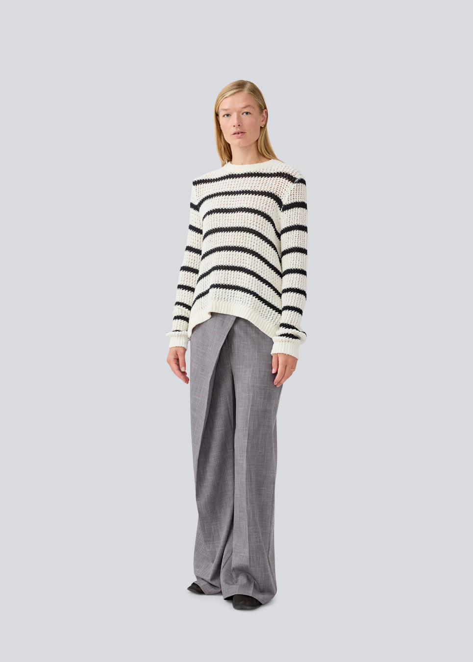 Klassisk strik i hvid med sorte striber i en løs pasform. MaddieMD stripe o-neck har en rund hals og slids i siderne. Modellen er 177 cm og har en str S/36 på.