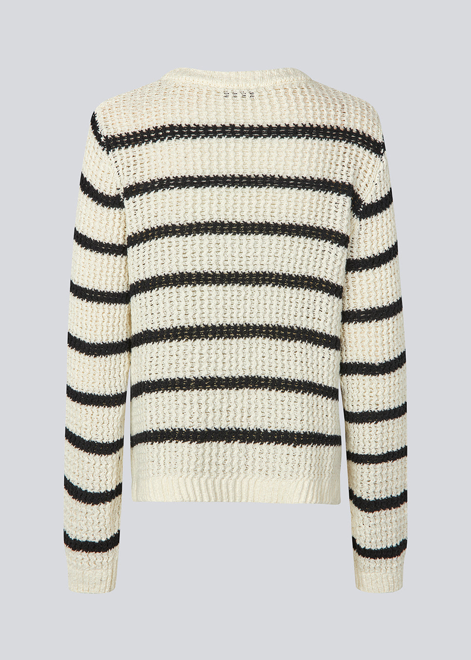 Klassisk strik i hvid med sorte striber i en løs pasform. MaddieMD stripe o-neck har en rund hals og slids i siderne. Modellen er 177 cm og har en str S/36 på.
