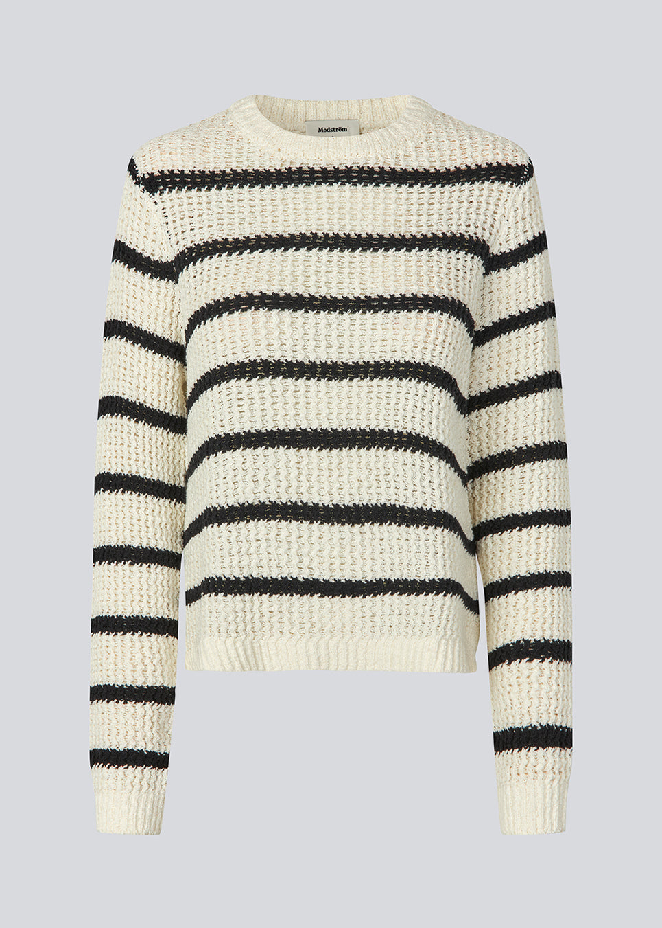 Klassisk strik i hvid med sorte striber i en løs pasform. MaddieMD stripe o-neck har en rund hals og slids i siderne. Modellen er 177 cm og har en str S/36 på.