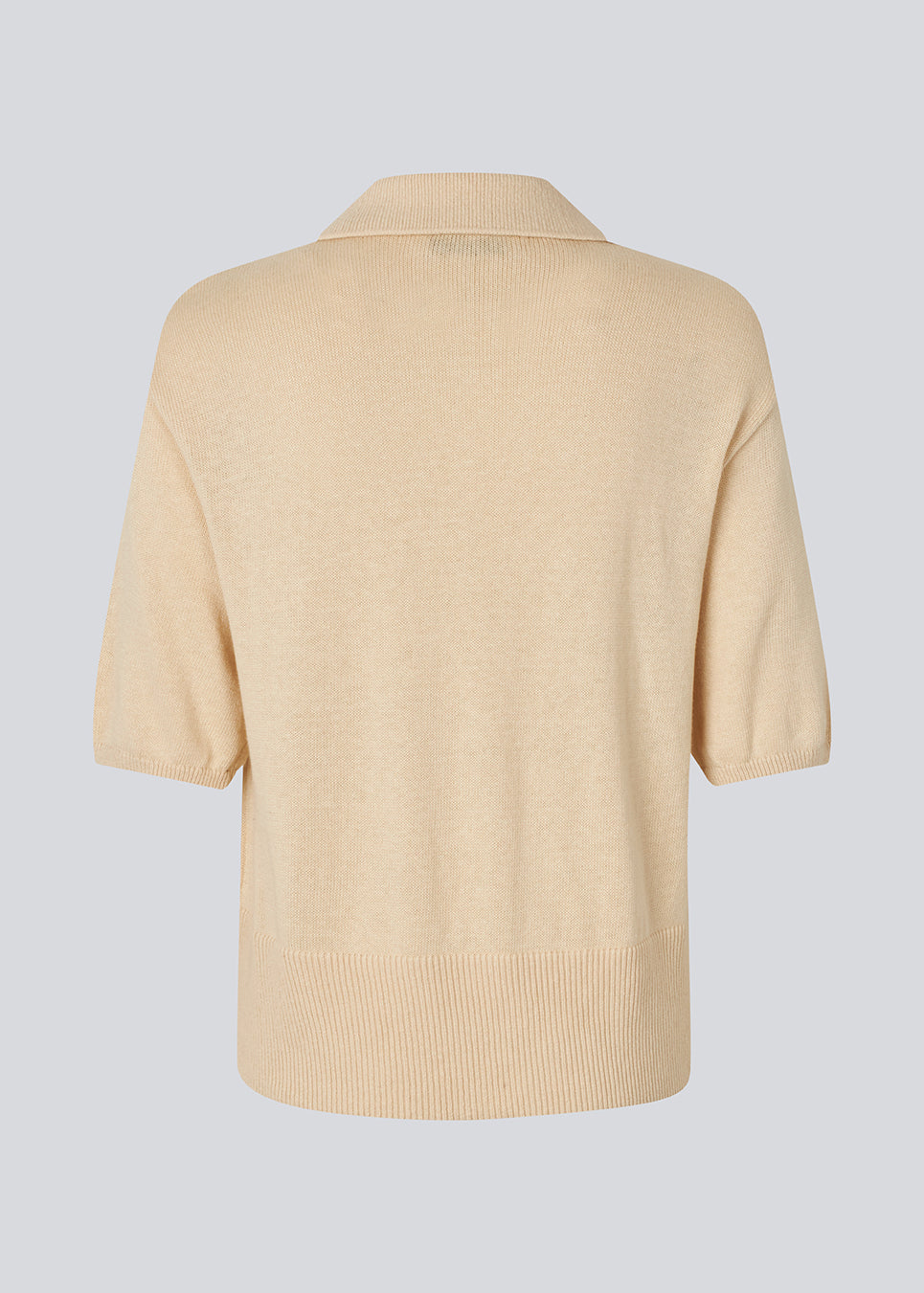 Blød strikket polo i beige i 100% bomuld. MalvaMD SS polo har en krave med stolpelukning og korte ærmer.