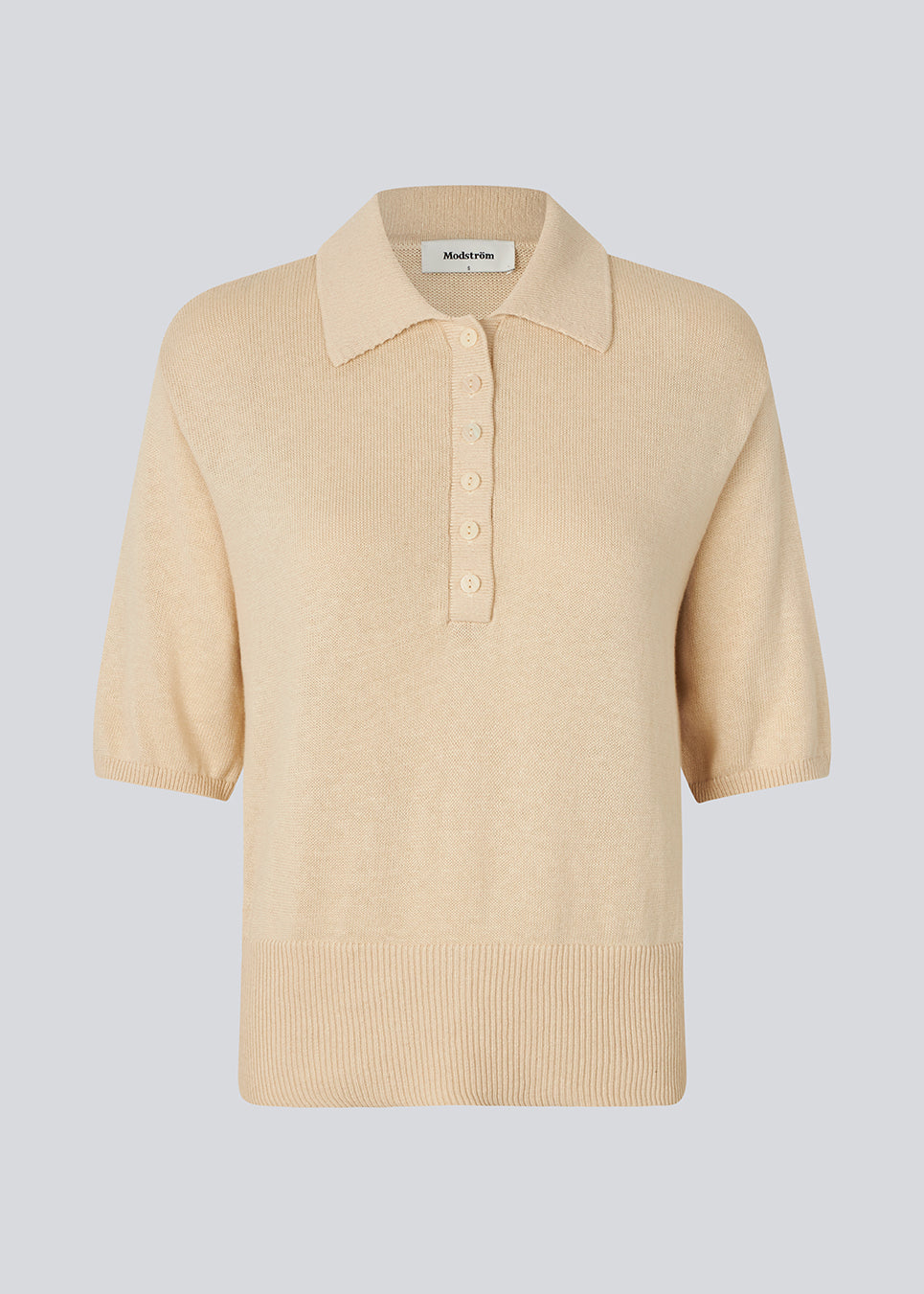 Blød strikket polo i beige i 100% bomuld. MalvaMD SS polo har en krave med stolpelukning og korte ærmer.