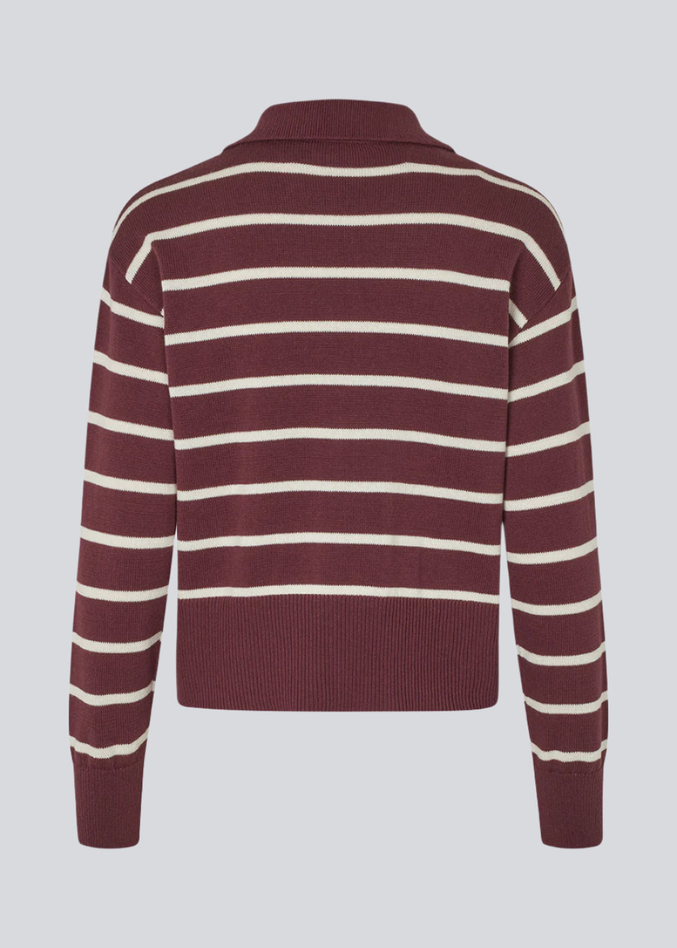 Blød strikket polo i bordeaux/mørkerød med hvide striber. MalvaMD stripe polo har en krave med stolpe lukning. Strikken er lille i størrelsen, og kort.