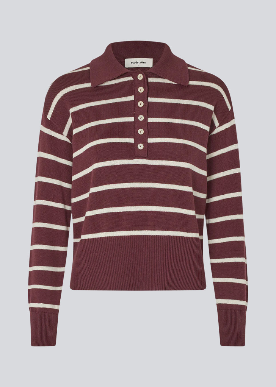 Blød strikket polo i bordeaux/mørkerød med hvide striber. MalvaMD stripe polo har en krave med stolpe lukning. Strikken er lille i størrelsen, og kort.