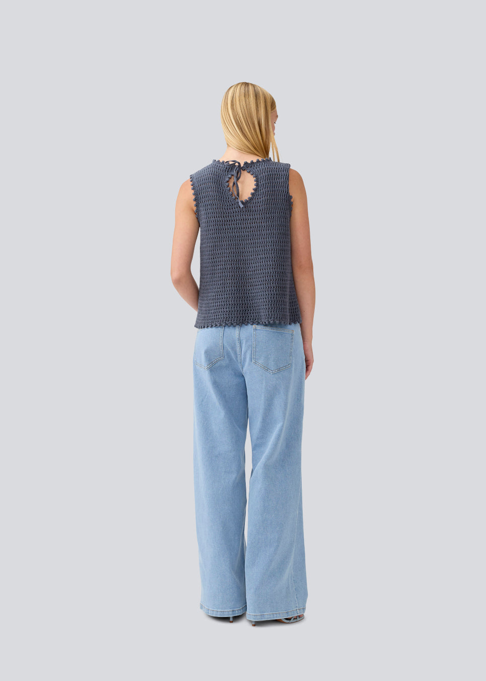 Hæklet top i mørkeblå uden ærmer i økologisk bomuld. MieMD top har detaljerede kanter og en dyb rygudskæring. Modellen er 177 cm og har en str S/36 på.