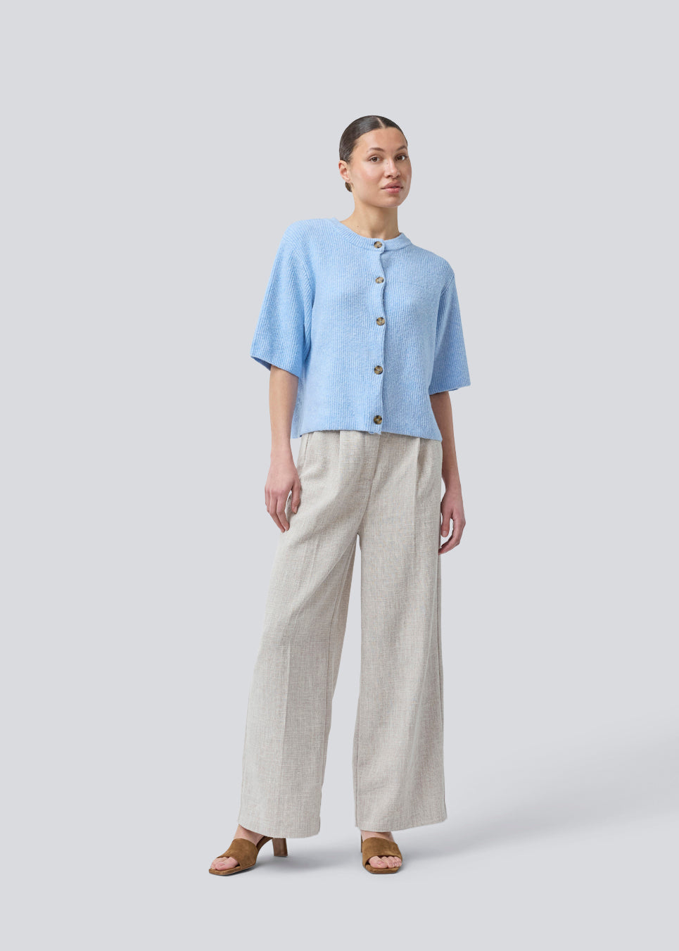 Kortærmet blå cardigan i blød strik. NoeMD cardigan har en løs pasform og knappelukning fortil.