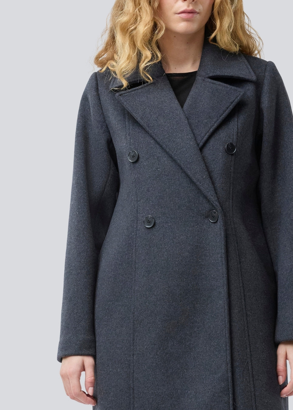 Klassisk, dobbeltradet uldfrakke med krave og revers. Olinamd coat er let figursyet, har foer og en slids bagpå. Modellen er 175 cm og har en str. s/36 på.