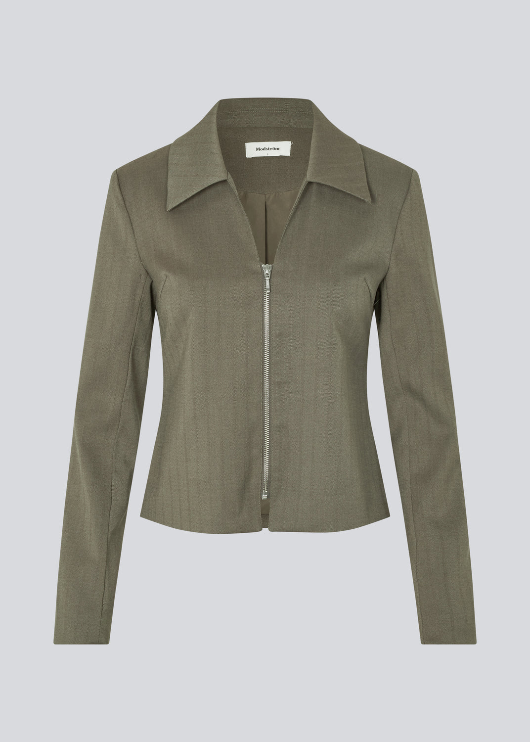 Figursyet blazer med lynlås lukning. Pedromd blazer har lange ærmer, V-udskæring og skjortekrave. Modellen er 175 cm og har en str. S/36 på.