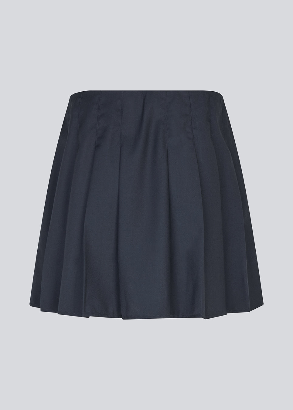 Kort nederdel med læg og mellemhøj talje i mørkeblå. Peggiemd skirt har en usynlig lynlås i siden. Modellen er 175 cm og har en str S/36 på.