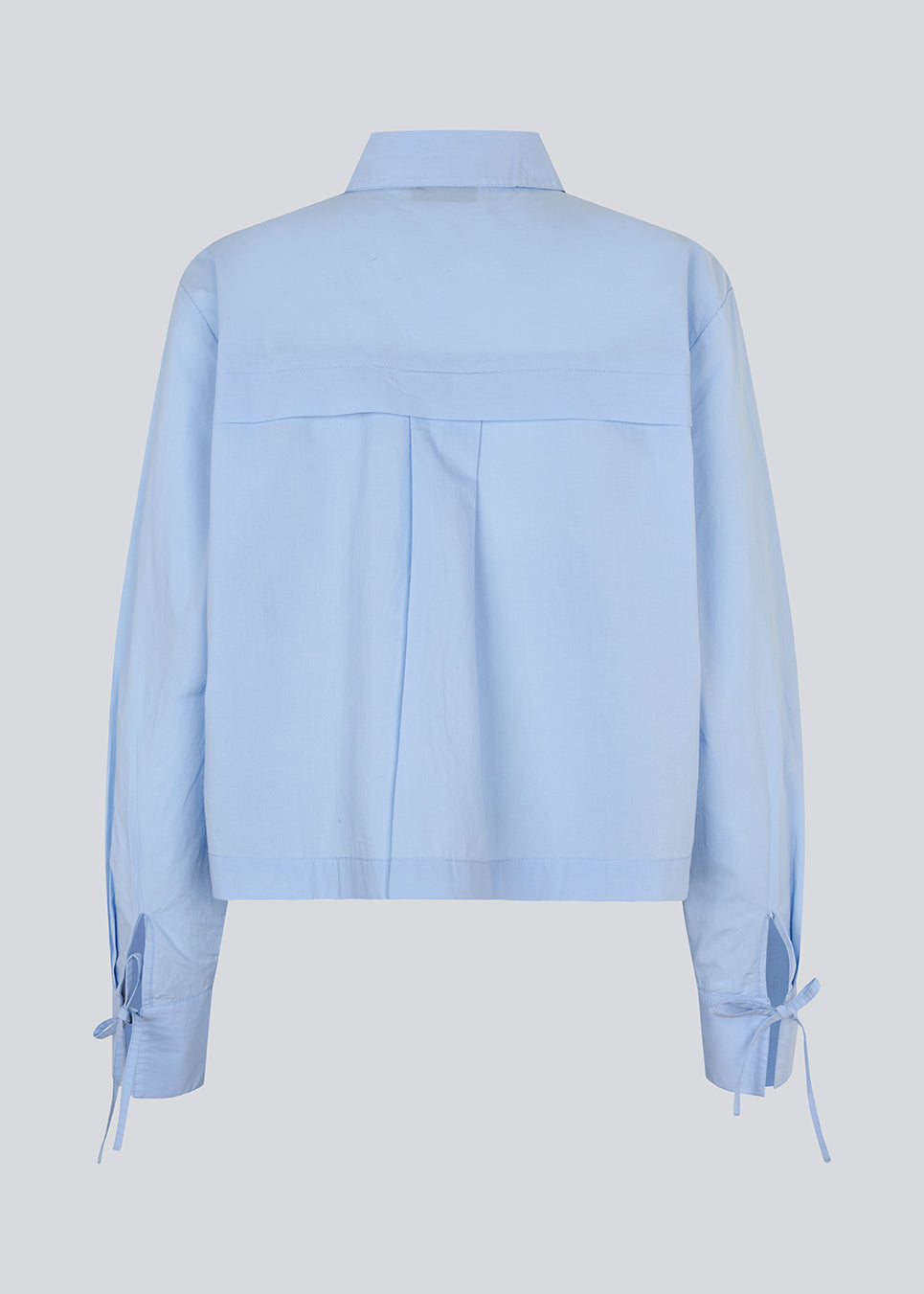 Kort skjorte i 100% økologisk bomuld. Poemymd shirt har en skjult knappelukning og manchet med bindebånds lukning. Modellen er 175 cm og har en str. s/36 på.