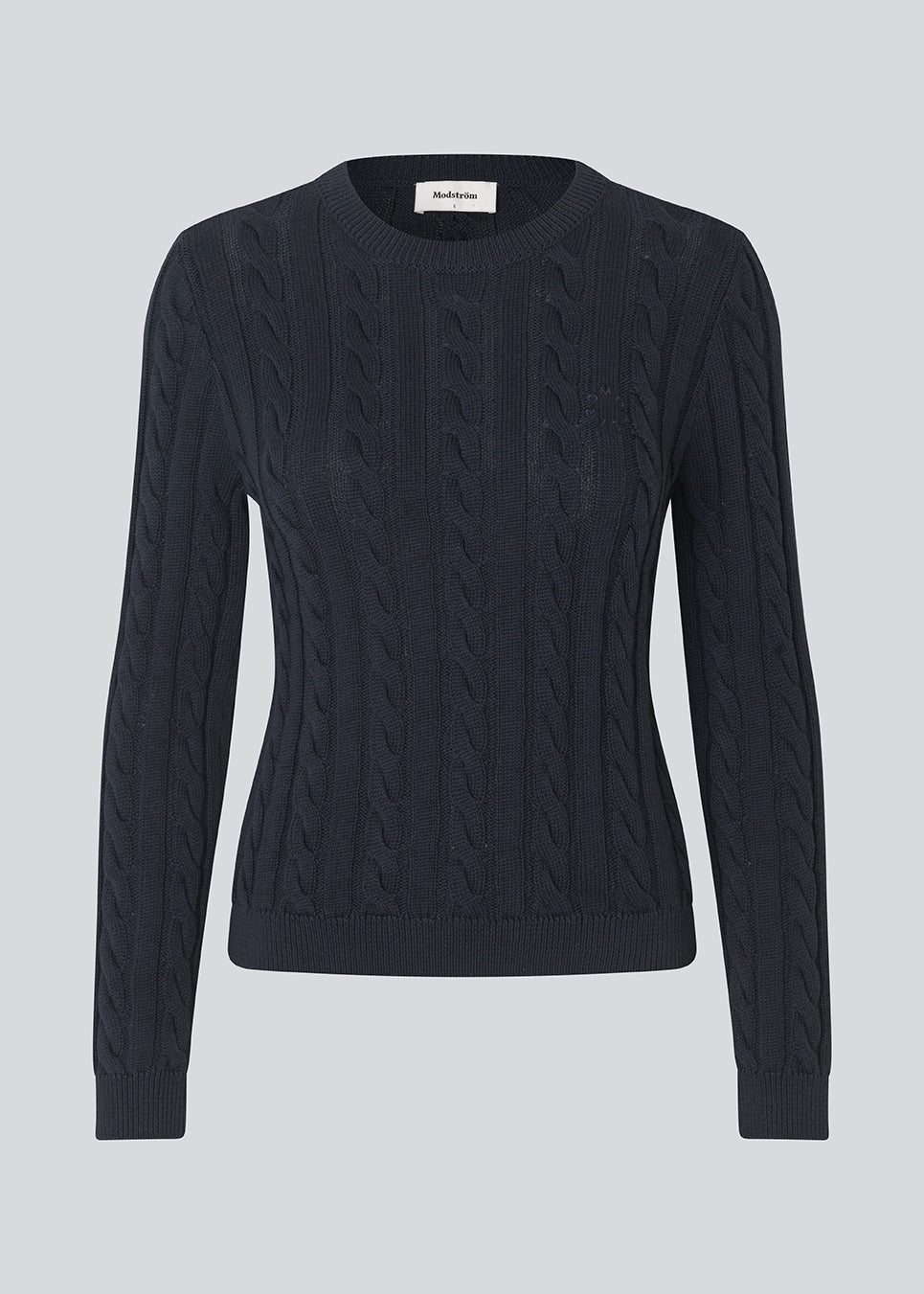Tætsiddende strik med rund hals i 100% økologisk bomuld. Sabremd o-neck er lavet i kabelstrik og har et broderet brystlogo. Modellen er 175 cm og har en str s/36 på.