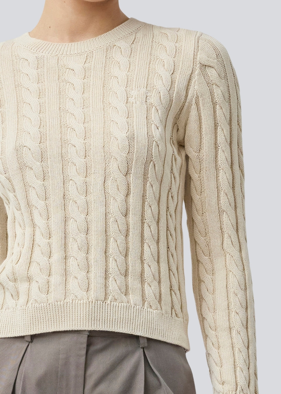 Tætsiddende strik med rund hals i 100% økologisk bomuld. Sabremd o-neck er lavet i kabelstrik og har et broderet brystlogo. Modellen er 175 cm og har en str s/36 på.