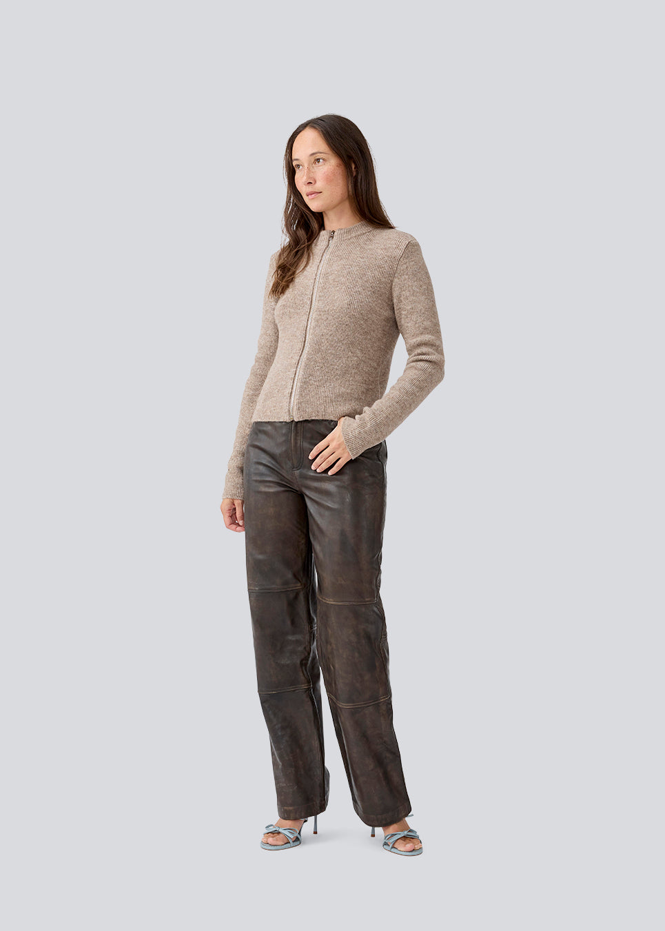Tætsiddende cardigan i blød strik i beige. TreeMD cardigan har en høj hals og en lynlås lukning fortil. 