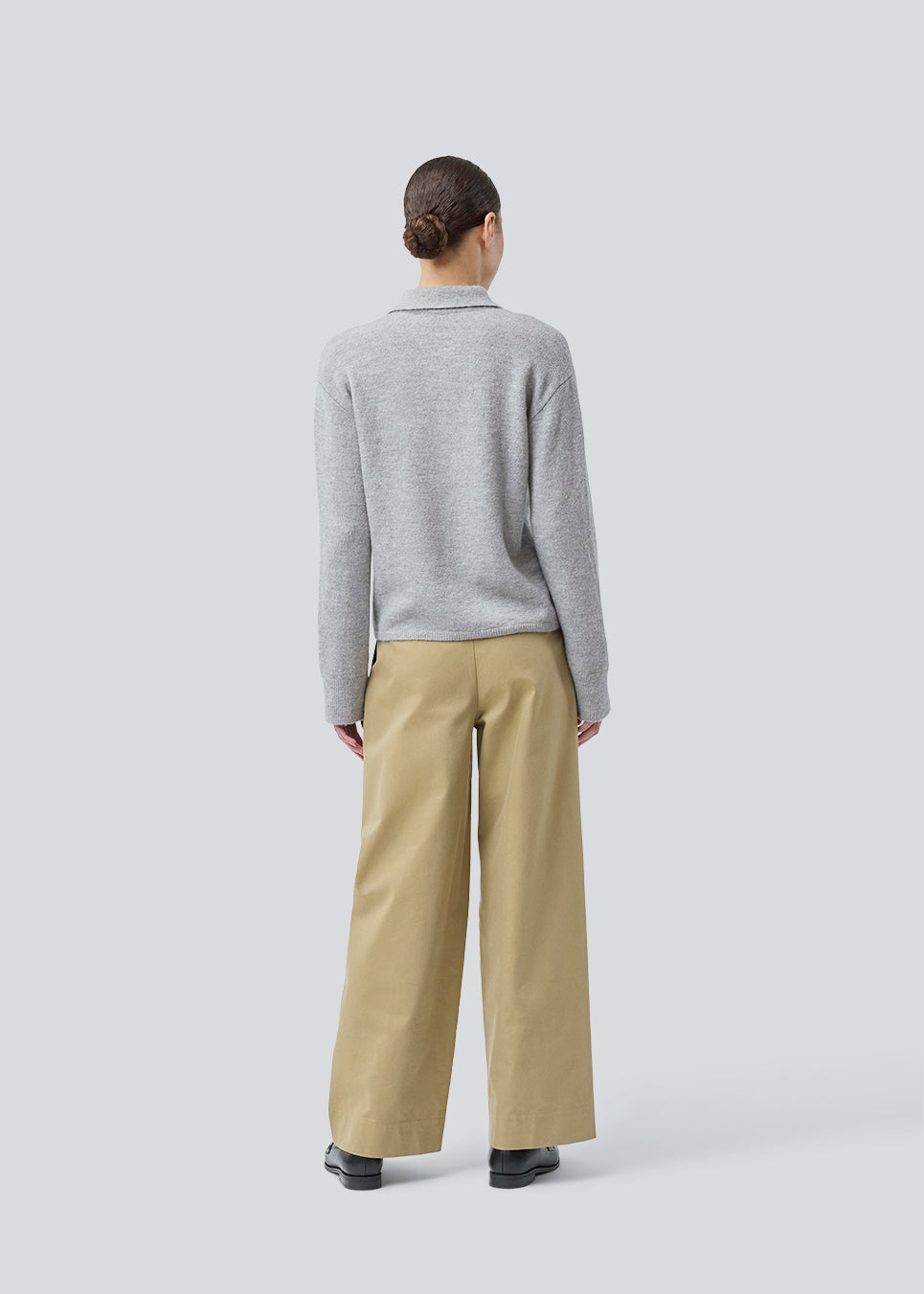 Strikket polo i grå med lange brede ærmer. Treemd polo har en stolpelukning og 4 knapper. Modellen er 175 cm og har en str. S/36 på.