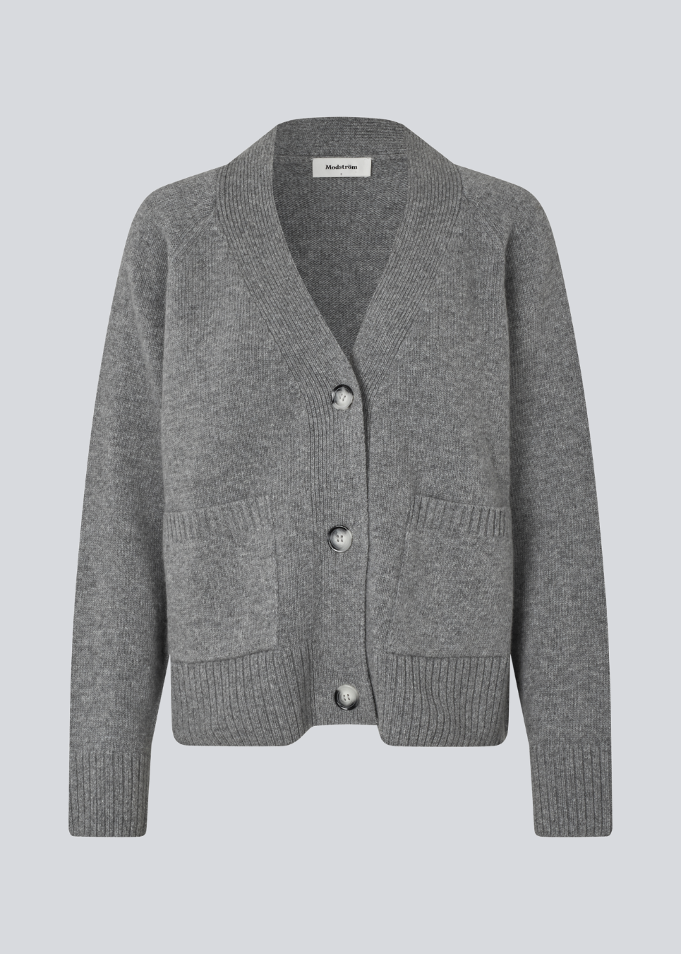 Grå strikket cardigan med V-udskæring i 100% uld. Petunamd cardigan har lange brede ærmer og to lommer fortil. 