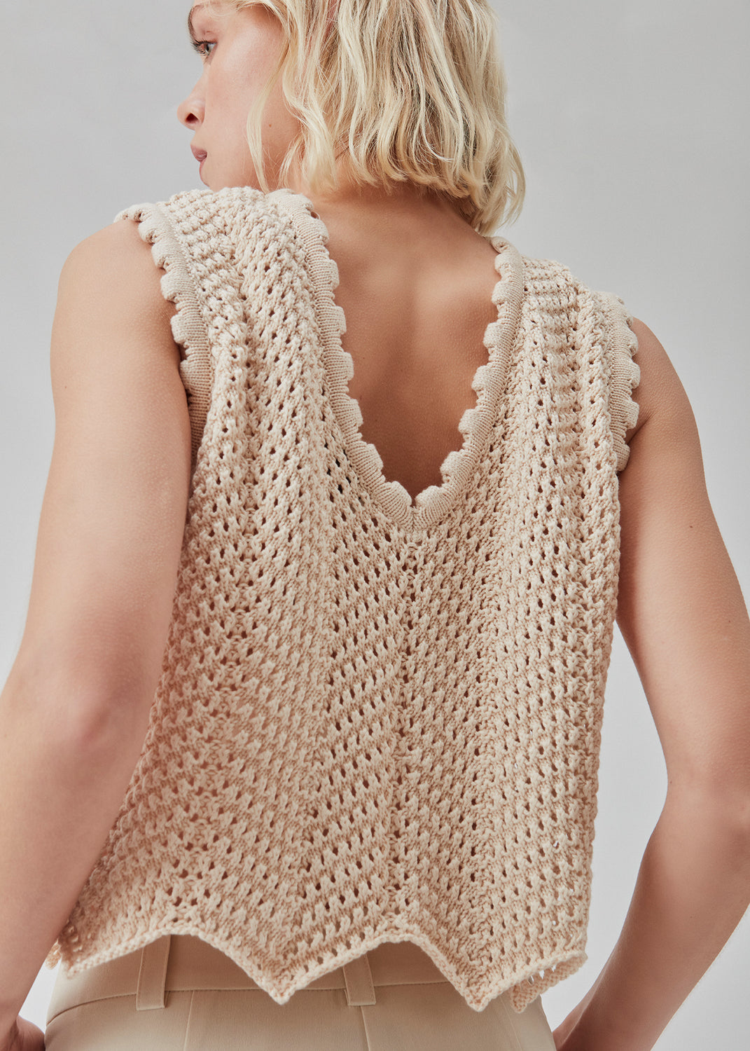 Hæklet top i beige uden ærmer i økologisk bomuld. CaryMD top har detaljerede kanter og en dyb v-udskæring på ryggen. Modellen er 177 cm og har en størrelse S/36 på.