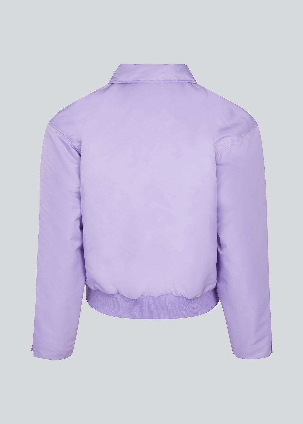 Kort, vatteret bomber jakke i lilla. ColtonMD jacket har krave, lynlås foran og lommer med trykknapper. Ribkant forneden.  Modellen er 177 cm og har en størrelse S/36 på.