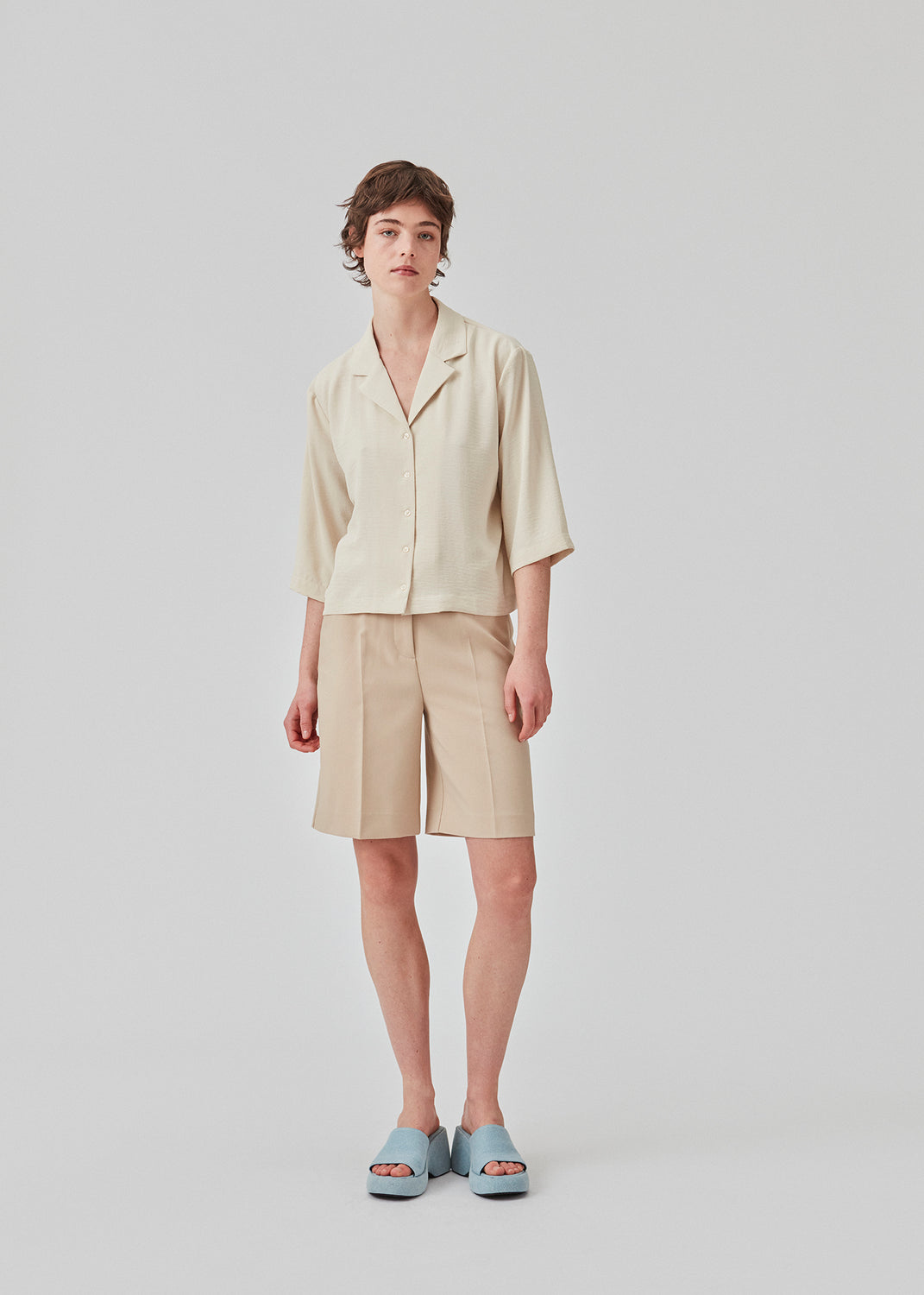 GaleMD shorts i beige har et klassisk design. Shortsene har knælange, vide ben med pressefolder som skaber et elegant look. Modellen er 173 cm og har en størrelse S/36 på.  Style med matchende blazer: Gale blazer, i samme farve.