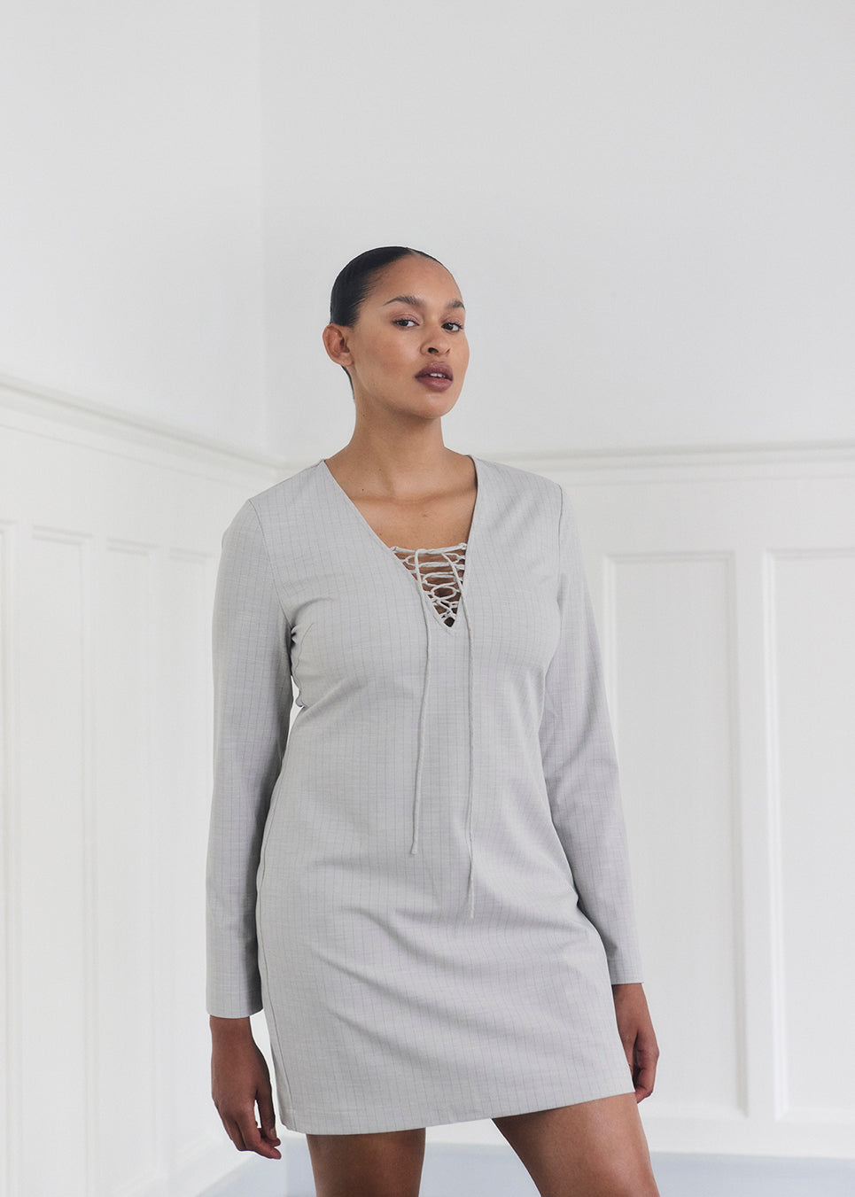 Kort figursyet kjole med v-hals med binde detalje. MickiMD dress har lange ærmer og en lynlås i siden.