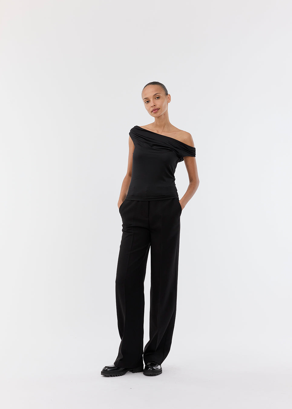 Off-shoulder top i sort i et elastisk materiale. HimaMD off-shoulder top har en tætsiddende pasform og er let cropped.