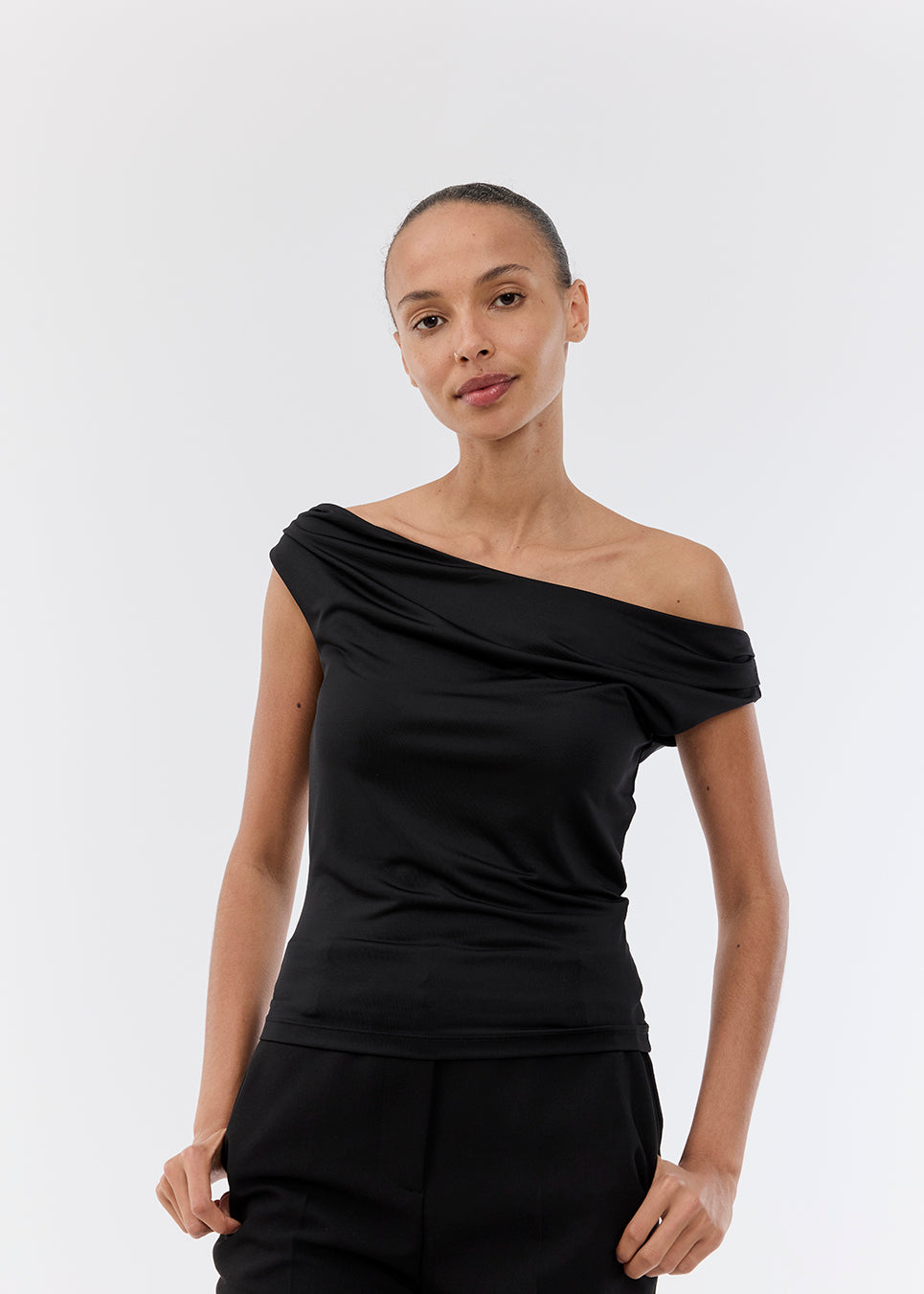 Off-shoulder top i sort i et elastisk materiale. HimaMD off-shoulder top har en tætsiddende pasform og er let cropped.