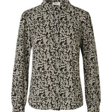 Skjorte i genanvendt polyester med et blomstret print. Oda print shirt har en afslappet silhuet med en lille krave, lange ærmer og knaplukning foran.