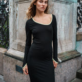 Tætsiddende maxi-kjole i strækbar rib. FaizMD dress har lange ærmer med slids, slids i siden af skørtet og asymmetrisk halsudskæring med kontrasterende kant. Modellen er 175 cm og har en størrelse S/36 på.