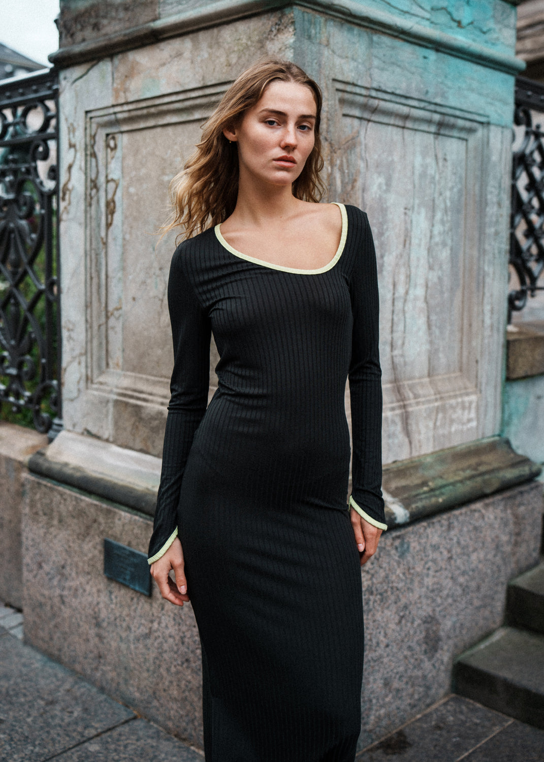 Tætsiddende maxi-kjole i strækbar rib. FaizMD dress har lange ærmer med slids, slids i siden af skørtet og asymmetrisk halsudskæring med kontrasterende kant. Modellen er 175 cm og har en størrelse S/36 på.