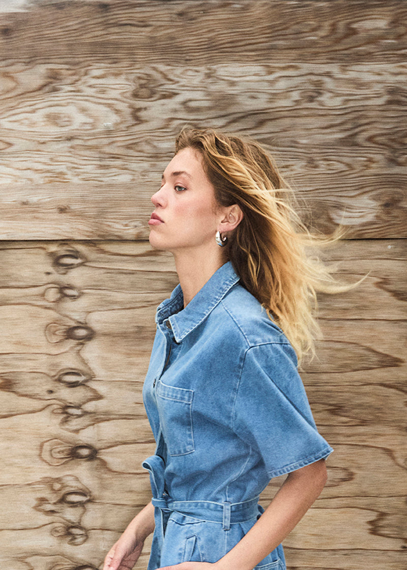 Kort denim playsuit med bindebånd i 100% økologisk bomulds denim. NaomaMD solid playsuit har en knappelukning fortil, skjorte krave og sidelommer.