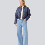 Let vatteret jakke i quiltet kvalitet med kort, ribbet krave og lynlås foran. HankMD jacket har en kort og løs facon. Produceret i genanvendt nylon. 
