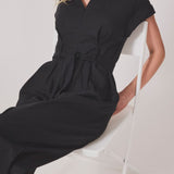 Sort jumpsuit med vidde ben og bindebånd i taljen. NedraMD jumpsuit har en krave, v-hals og lynlåslukning fortil.