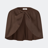 Tailormd Cape er en elegant satin-cape, der tilfører et raffineret og dramatisk udtryk til ethvert outfit. Designet falder let over skuldrene og lukkes foran med en dekorativ knudedetalje, som skaber et blødt, flydende fald. Brug den over en kjole til særlige anledninger eller som et eksklusivt lag over en enkel top for et sofistikeret look. Modellen er 175 cm høj og bruger størrelse S/36.
