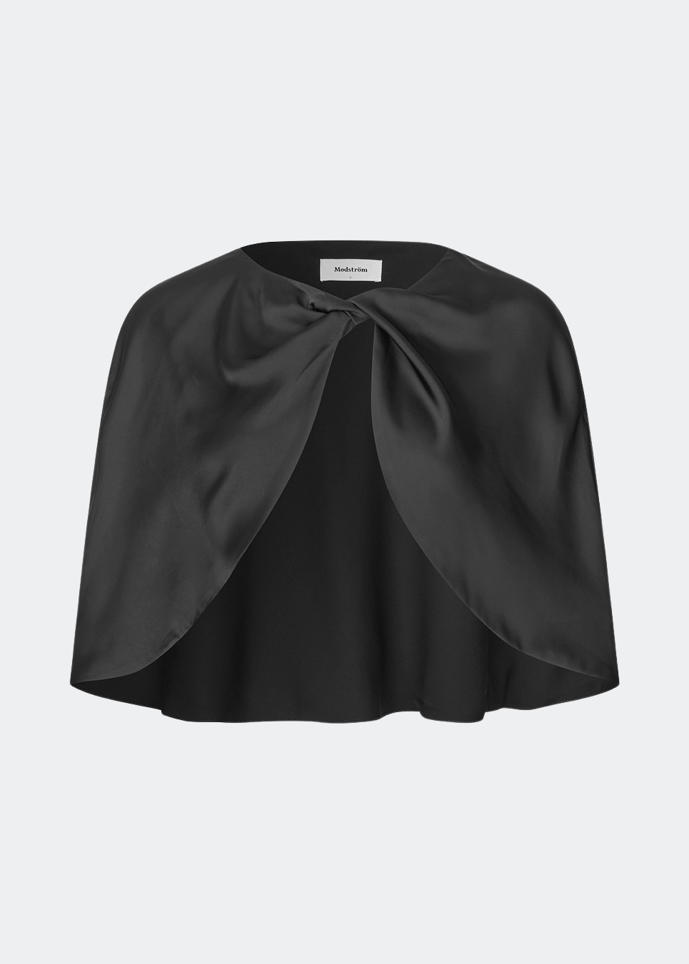Tailormd Cape er en elegant satin-cape, der tilfører et raffineret og dramatisk udtryk til ethvert outfit. Designet falder let over skuldrene og lukkes foran med en dekorativ knudedetalje, som skaber et blødt, flydende fald. Brug den over en kjole til særlige anledninger eller som et eksklusivt lag over en enkel top for et sofistikeret look.&nbsp;